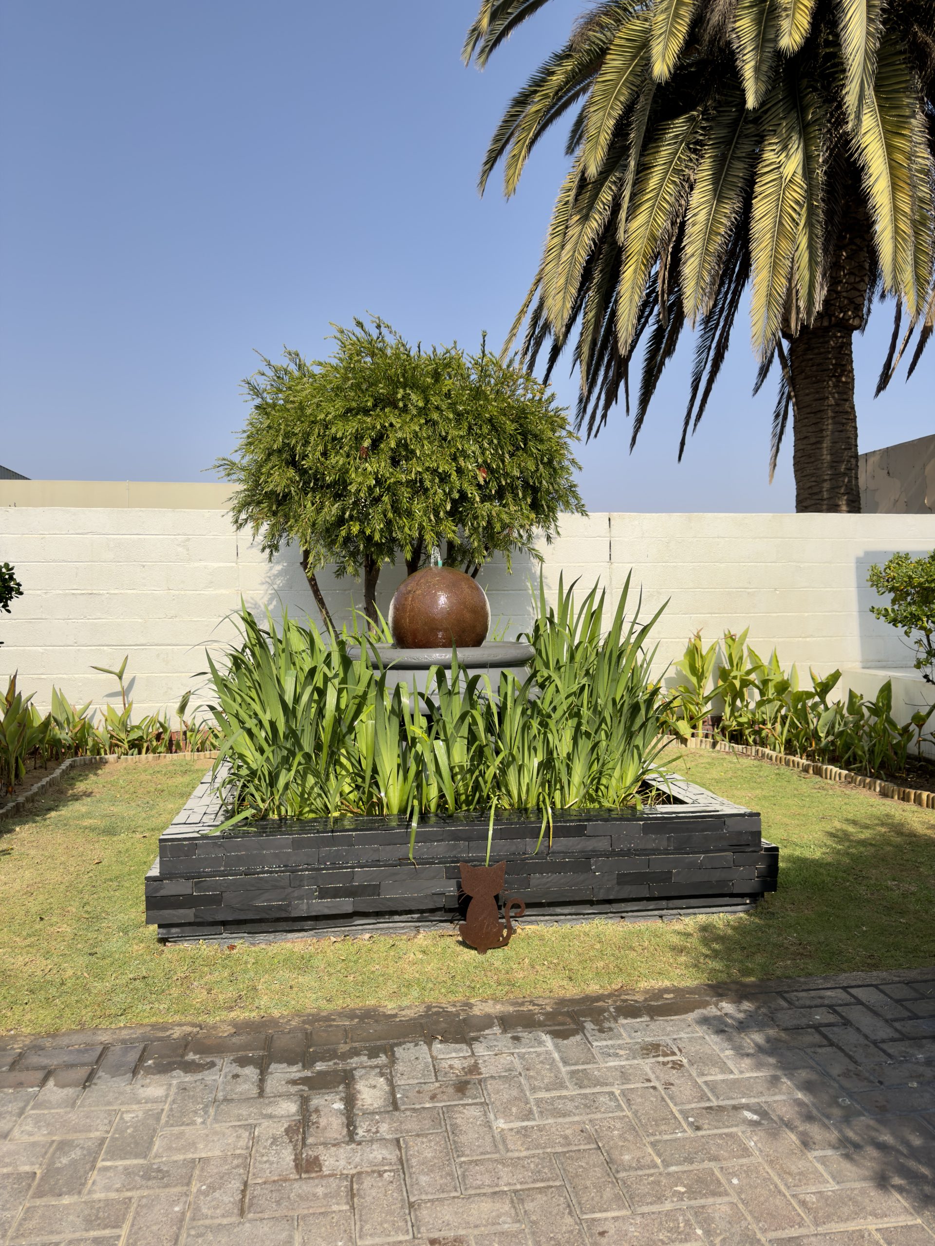 Stone water feature and planted bed in the garden at The Langholm Hotel, Walvis Bay